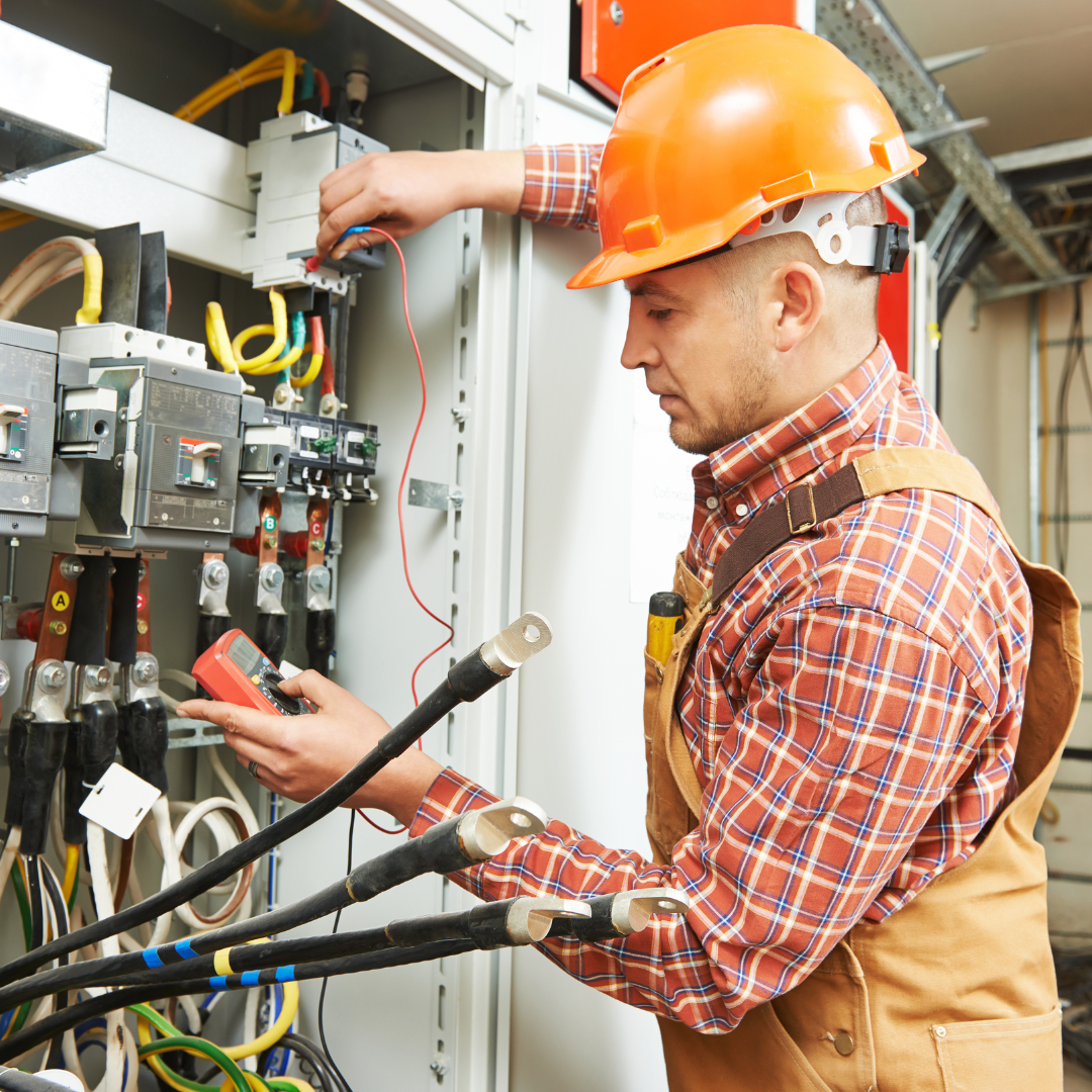 An electrician working on a power distribution panel.